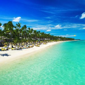 Tropical vacation in Punta Cana, Dominican Republic. Aerial view over beach resort. Parasailing. Sunbathing.