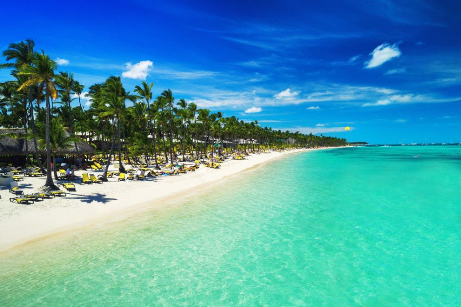 Tropical vacation in Punta Cana, Dominican Republic. Aerial view over beach resort. Parasailing. Sunbathing.